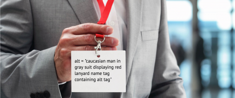 caucasian male in gray suit displaying red lanyard name tag displaying alt tag